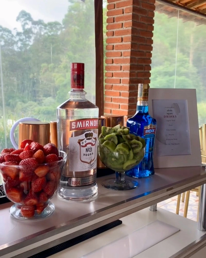Bar montado em área externa com frutas, garrafas e canecas de cobre